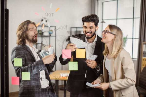 Happy rich business people celebrating income growth indoor